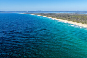 Aerial image capturing Janies Corner at Seven Mile Beach in Forster, showing rolling ocean waves meeting a wide sandy shoreline