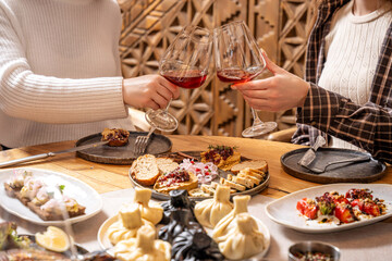 Friends clinking glasses during georgian lunch