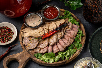 Gourmet assorted meat platter with sauces and herbs