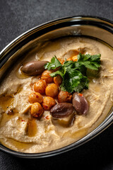 Creamy hummus bowl with chickpeas and olives