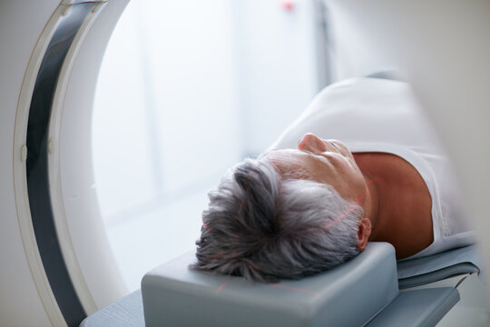 Healthcare, mri machine or senior woman in clinic for medical procedure, radiology or ct scan for diagnosis. Patient, skull assessment or tech for tumor screening, cancer detection or monitor growth