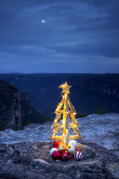 Rustic timber Chirstmas on a cliff in blue hour with twilight moon in sky