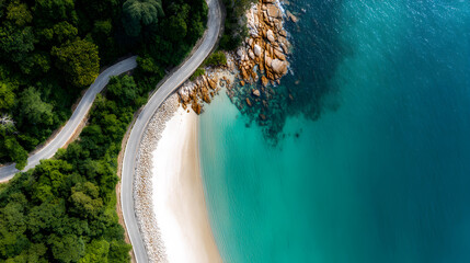 Coastal Serenity: An aerial perspective captures a winding road embracing a breathtaking coastline, with a pristine sandy beach kissed by the azure embrace of the sea.