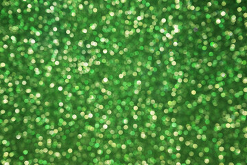 Green glitter bokeh particles background. Green background with soft bokeh lights.