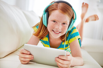 Tech, tablet and portrait with girl on sofa of home for streaming service, cartoon app and search. Online movie subscription, multimedia and film with child in living room of house for headphones