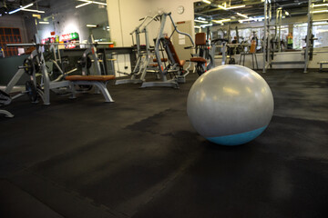 a fitball on the floor in the gym. Fitness equipment placed on the gym floor in an empty workout...