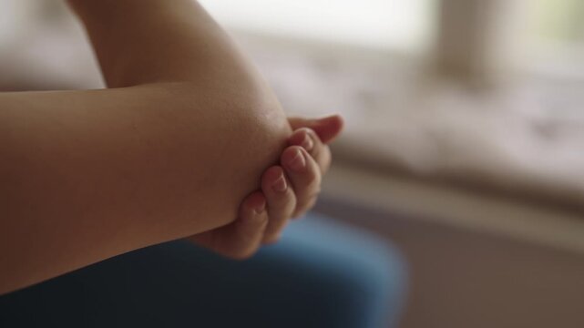 Close-up of unrecognizable female applying moisturizing cream to elbow, hydrating dry skin and providing nourishment for daily personal self-care and beauty routine, focusing on skin health.