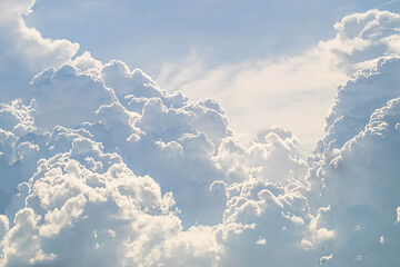 Mighty cumulus clouds billowing across a bright blue sky