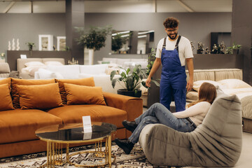 Obraz premium Salesperson helping customer choosing furniture in store