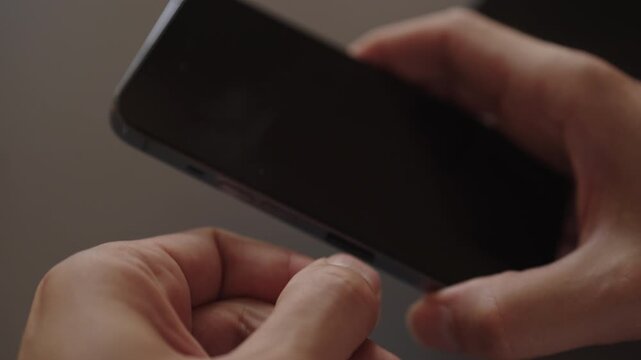 Male hands inserting sim card ejector tool into smartphone, replacing or transferring data for mobile communication and connectivity, close-up. Concept of telecom, repair, device management.