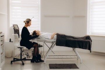 Cosmetologist performing facial treatment on client at beauty salon