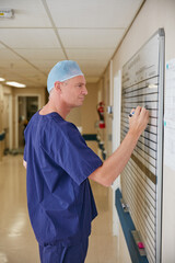 Writing, surgeon or man in hospital with whiteboard, operation theater roster or schedule plan....