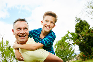 Happy, piggyback and father in park, boy and nature with relationship, playing and portrait. Family, parent and dad carrying son, weekend break and bonding together with smile, laughing and games