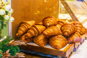 Fresh butter croissants stacked on bakery display