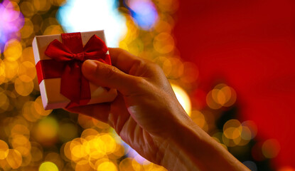 A Man  Hand Holding a Small Christmas Gift Box