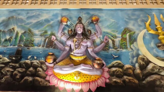 A rich, detailed painting of Lord Shiva in divine form with multiple arms holding symbolic objects. The oceanic background and lotus base reflect cosmic creation and spiritual harmony.