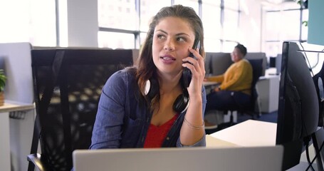 Woman answering smartphone call at desk viewing charts tapping tablet typing laptop discussing data - Powered by Adobe
