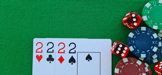 Four Twos Playing Cards and Poker Chips on Green Felt Tabletop