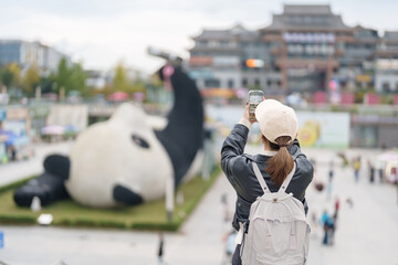 Happy woman traveler travel in Dujiangyan city. Tourist sightseeing Yangtianwo Square and Guanxian...