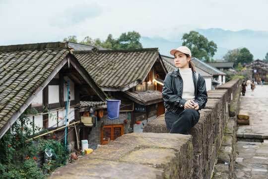 Happy woman traveler travel in Dujiangyan city. Tourist sightseeing the Ming City Wall at Guanxian Ancient City near Chengdu. Landmark and popular for tourism attraction in Sichuan, China