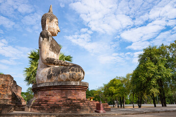 Obraz premium Ancient sculpture of a seated Buddha on the ruins of the Wat Mae Chon buddhist temple. Sukhothai, Old town.Thailand