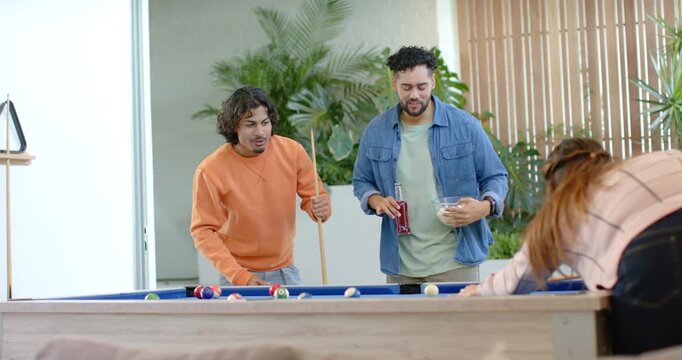 Triggered by woman pocketing ball male friends leaning toward pool table at home calling next shot