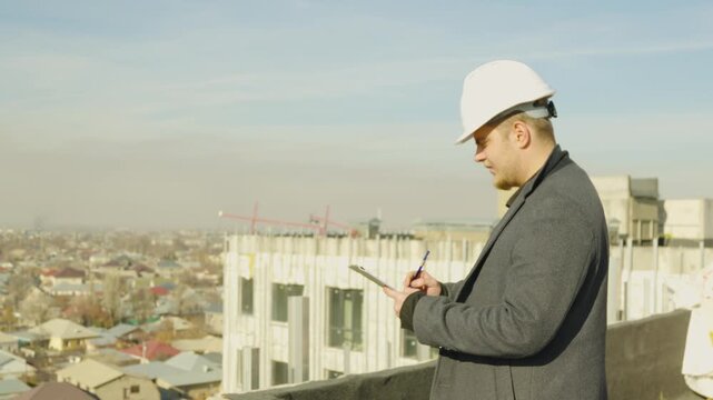 Male engineer ooking at the city skyline from a rooftop construction