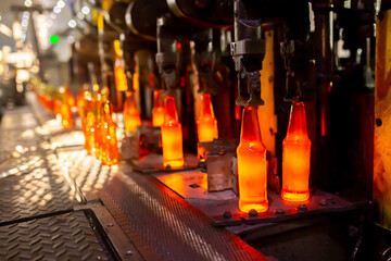 Glass factory, production of glass containers. Molten glass is blown into molds. Robotics in industry. Modern technologies, robotic machines produce products. Technological work at the plant.