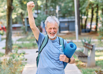 Portrait of a happy active senior man posing after yoga class or exercising outdoors, healthy lifestyle and vitality concepts