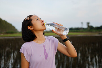 Woman drinking water after exercise.