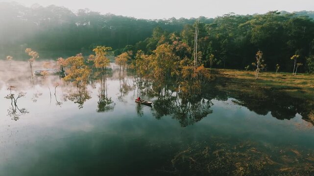 4K Aerial View Of Boat Rowing Through Misty Submerged Forest in Suoi Tia Tuyen Lam lake, Dalat Vietnam
Early morning mist, an ethereal, fairyland atmosphere. Calm waters reflecting unique flood forest