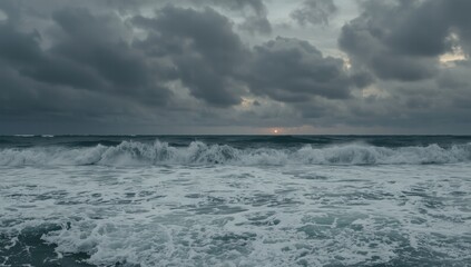 Dark stormy ocean waves crashing under cloudy sky at sunset  