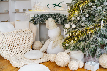 Cozy winter room with decorated tree and snowman beside fireplace and sofa