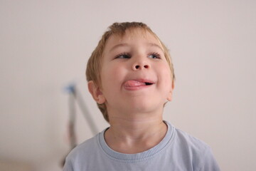 Little boy making silly face sticking out tongue