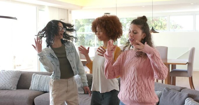 Three female friends waving, swaying, mirroring left friend raising finger, ending hugging at home