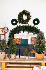 Cozy bedroom decorated with festive evergreen trees and glowing wreaths