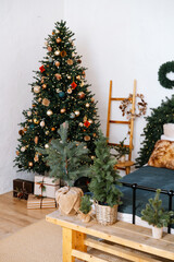 Festive decorated evergreen tree with presents and smaller trees indoors.
