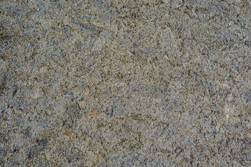 Rough natural granite surface with varied grey and brown speckled texture