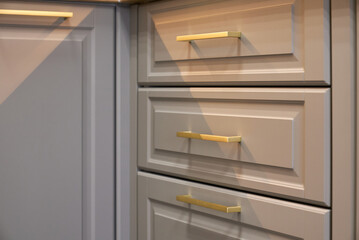 Kitchen cabinets with golden handles in a modern setting