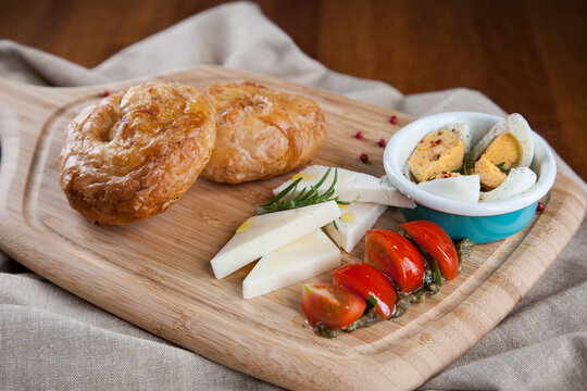 Traditional Turkish Breakfast with Boyoz Pastry, Cheese, Tomatoes, and Eggs