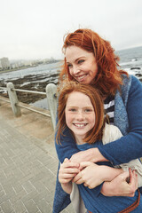 Hug, smile and child with mom for beach, bonding or relax together for relationship. Family, support and mother with daughter on holiday outdoor with ocean, portrait or travel for weekend or vacation