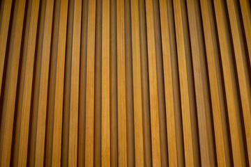 Full frame of a seamless modern wooden slat wall texture, creating a warm, contemporary, and geometric background.