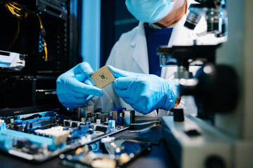 The technician is putting the CPU on the socket of the computer motherboard. electronic engineering electronic repair, electronics measuring and testing, repair
