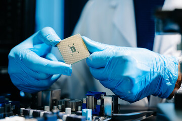 The technician is putting the CPU on the socket of the computer motherboard. electronic engineering...