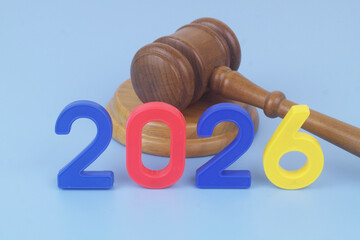 Judge gavel and numbers 2026 on blue background. Concept of laws changing in year 2026.