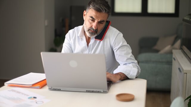Mature man multitasking working from home office