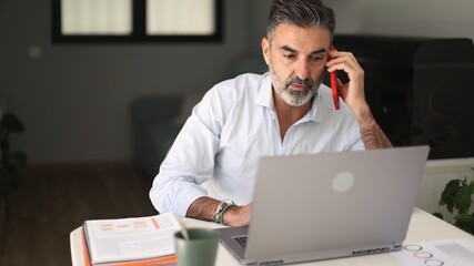 Busy businessman working remotely with laptop and phone call