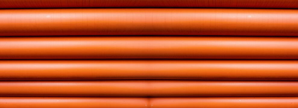 Stack of Orange pipe made of polyvinyl chloride