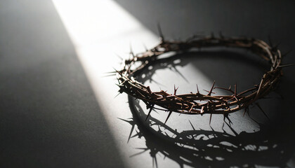 Fototapeta premium Jesus crown of thorns on black surface with gentle light streaming from window. Spiritual, somber