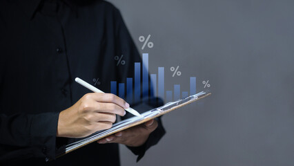 Businessman writing on clipboard with virtual growth chart and percentage symbols.